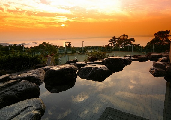 Open-air bath under clear sky with view of Seto Inland Sea.