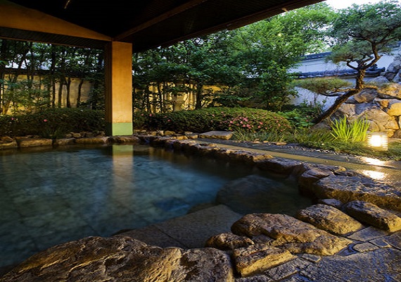Open-air bath surrounded by elegant Japanese garden.