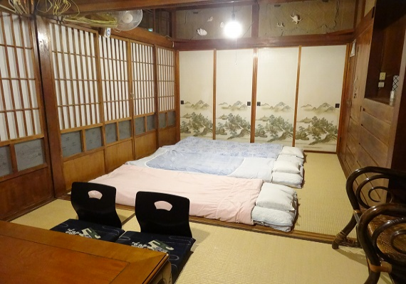 沖縄古民家の一番座と二番座をつなげて一部屋にした、ごーやー荘でも一番いいお部屋です。床の間や趣のある欄間など、木造りのあたたかさを感じながら、ゆったりとおくつろぎください。