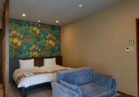《ラ・カーサツイン》Room101（36.9平米）やさしく落ち着きある色調でまとめた客室。窓の向こうにはプールが広がり、開放的なリゾート感が漂います。