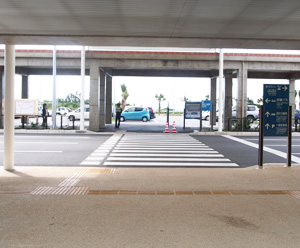 Cross at the cross walk and there is a sign of shuttle bus station of rent-a-car.